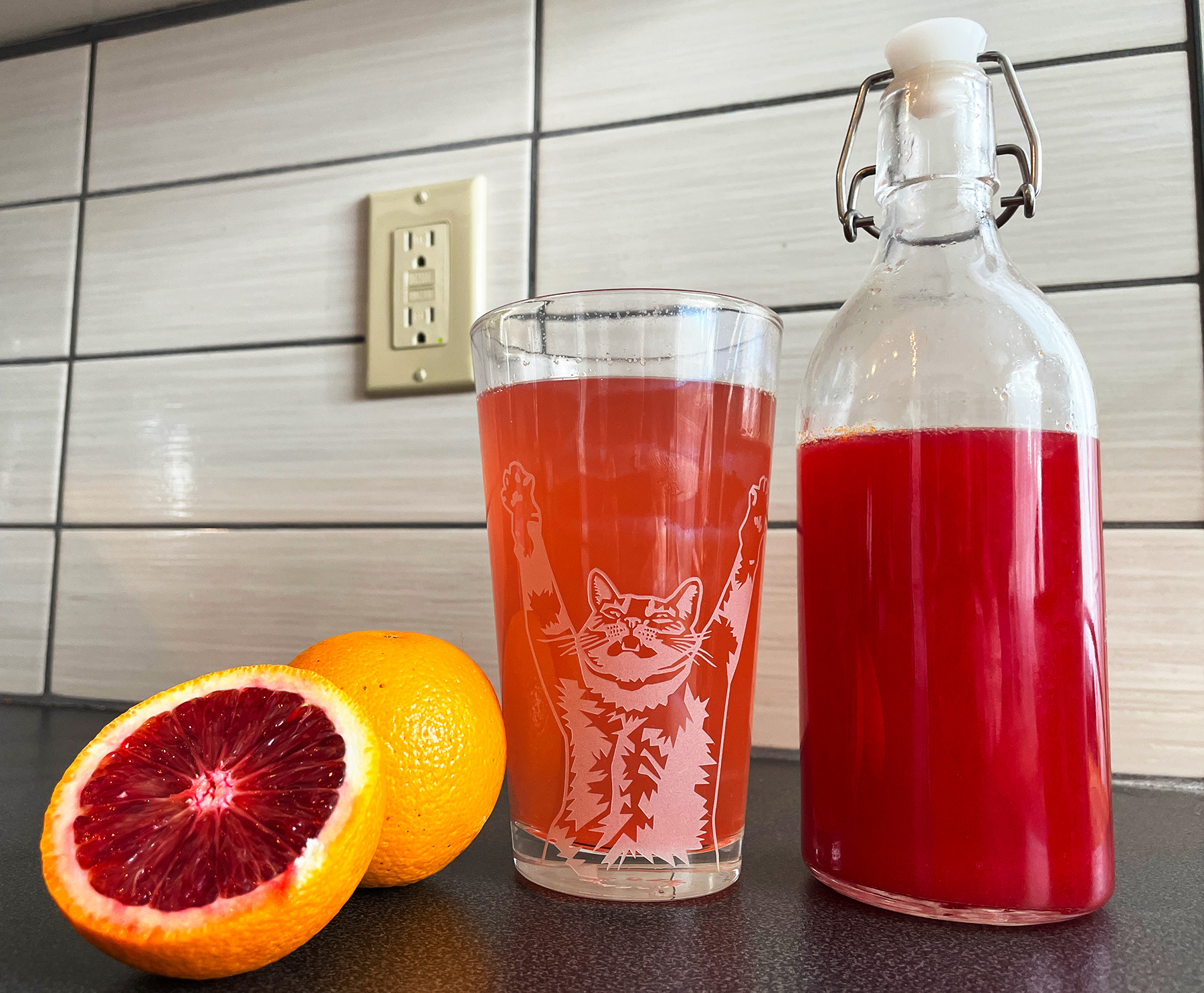 Spiced blood orange shrub mix with blood oranges and a glass of shrub